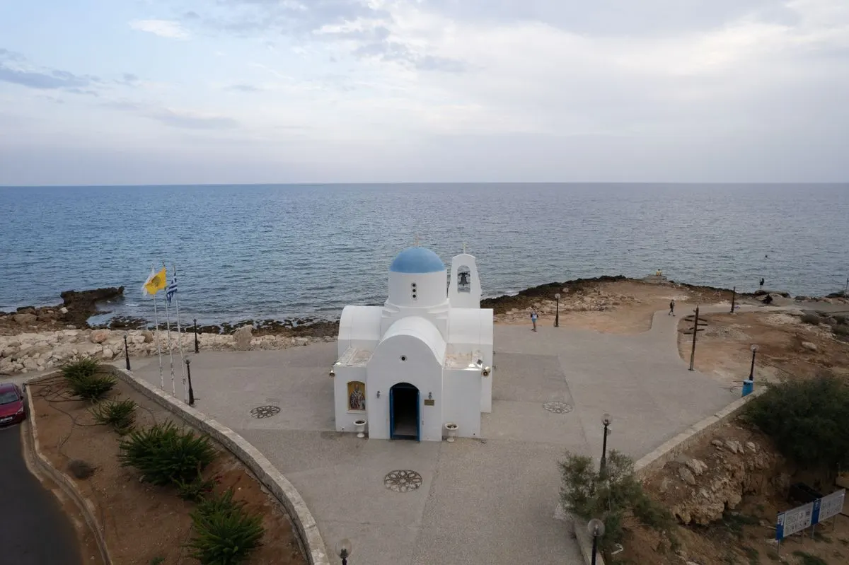 Aerial view of a white church with a blue dome by the sea in Pernera, Famagusta, Cyprus. - Photo…