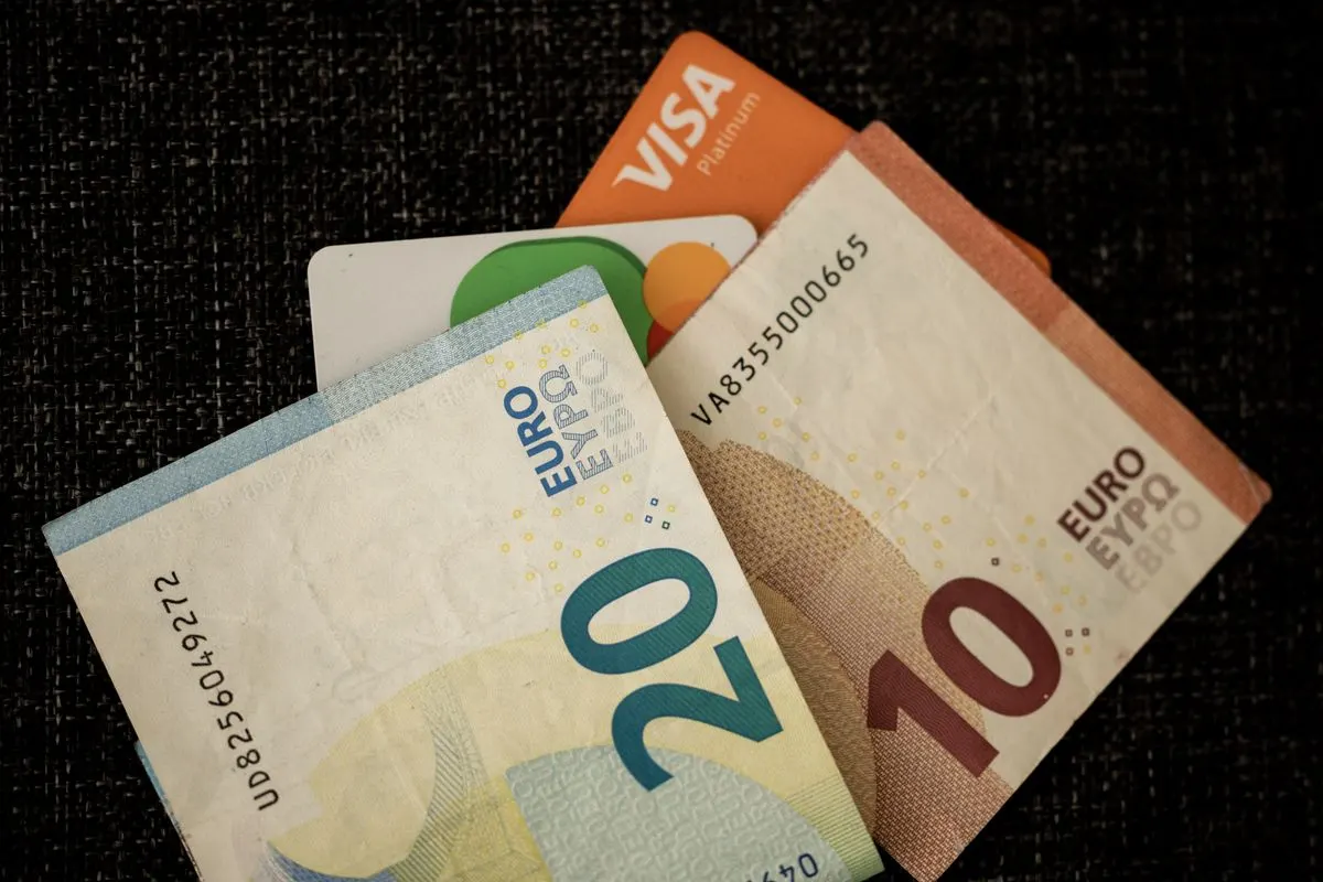 Close-up of euro banknotes and credit cards on a dark textured surface. - Photo by Engin Akyurt…