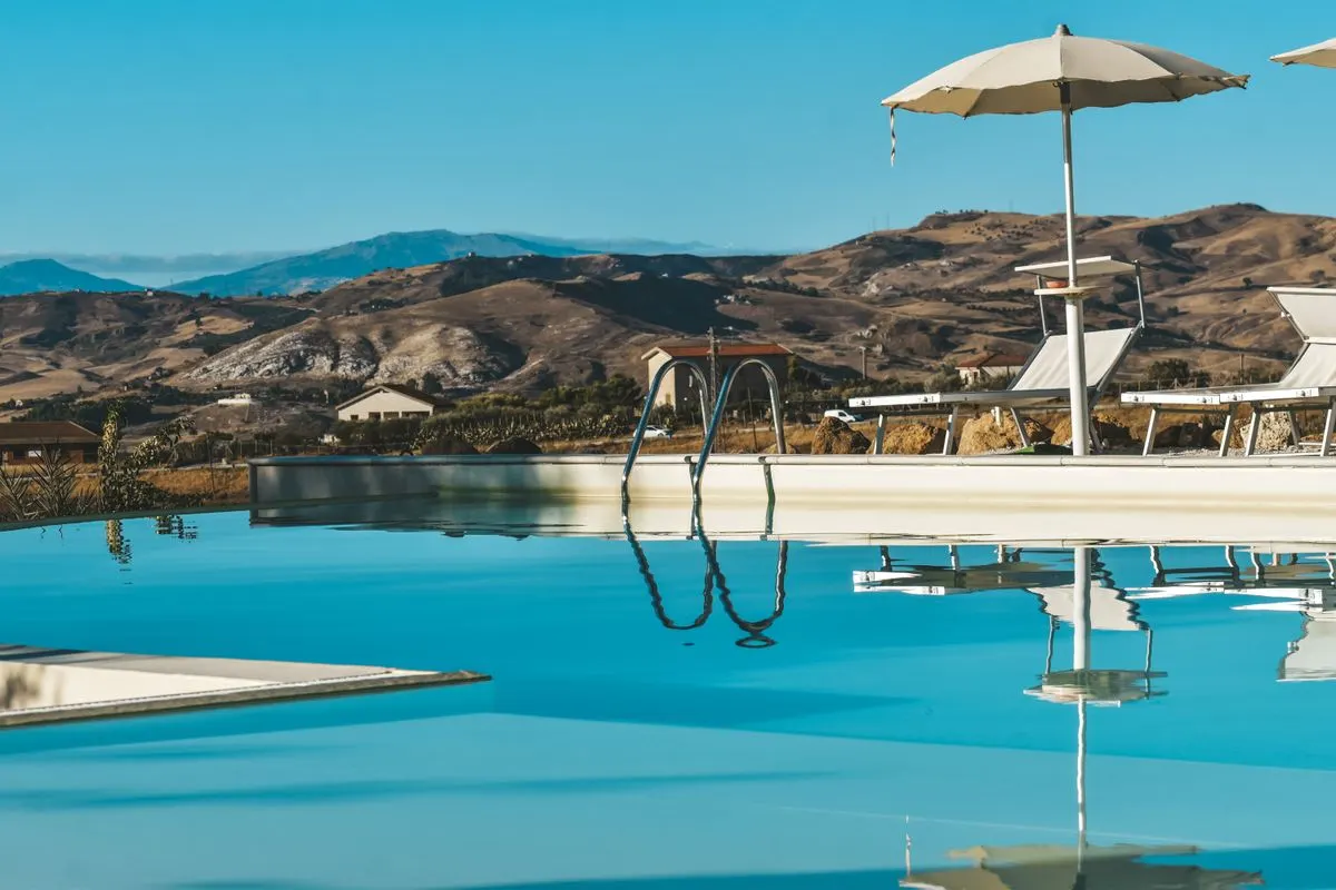 Relaxing poolside view at a resort with mountains in the background, perfect for a tranquil…