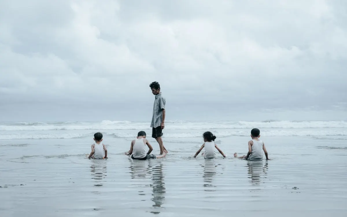 Young children playing at Bengkulu Beach, Indonesia, on a cloudy day. - Photo by Rizki Koto on…