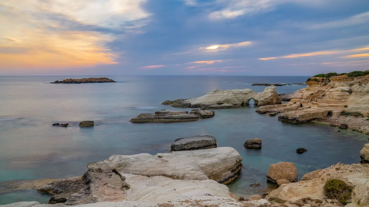 Peaceful sunset over a rocky coastline with ocean view in Cyprus. Ideal for travel and nature…