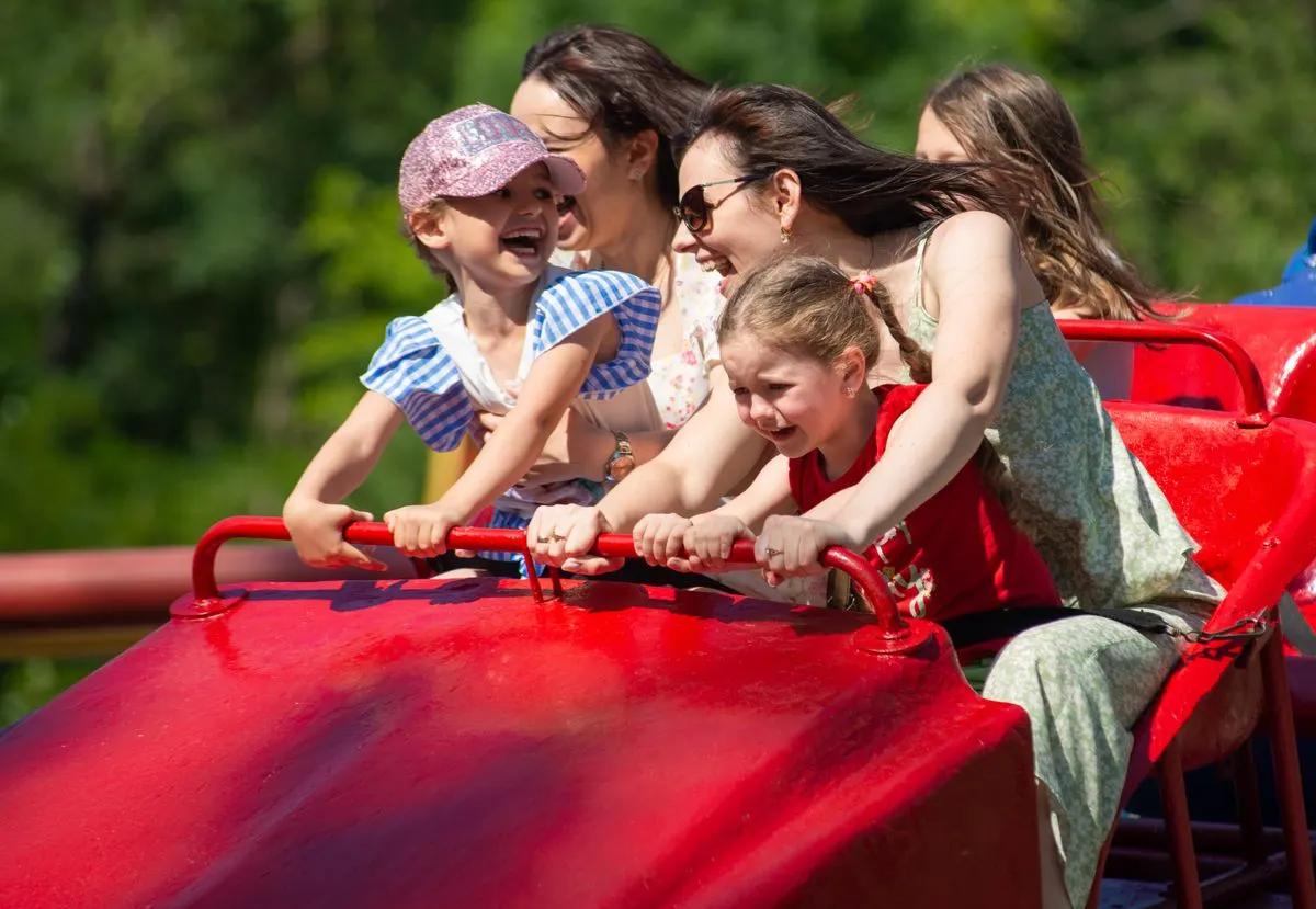 Joyful family experiencing excitement and exhilaration on a roller coaster ride, full of smiles…