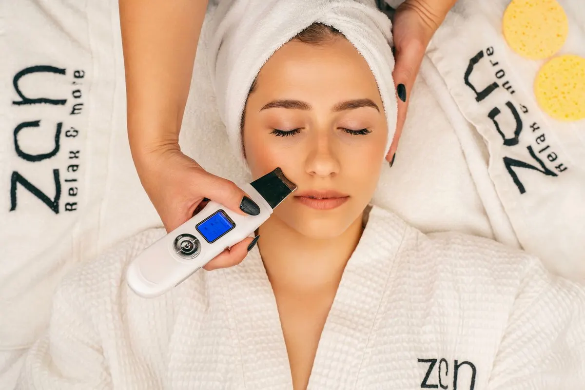A serene spa experience with a woman getting a facial treatment using an ultrasonic device. -…