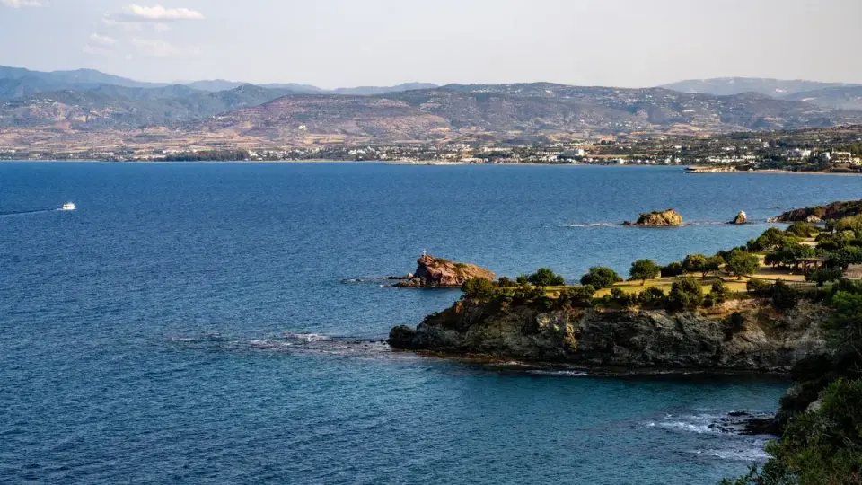 Breathtaking view of a rocky coastline with expansive blue sea under a clear sky. - Photo by…