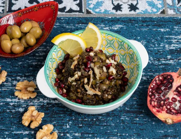 Delicious Mediterranean dish with pomegranate, olives, and lemon slices. - Photo by Shameel…
