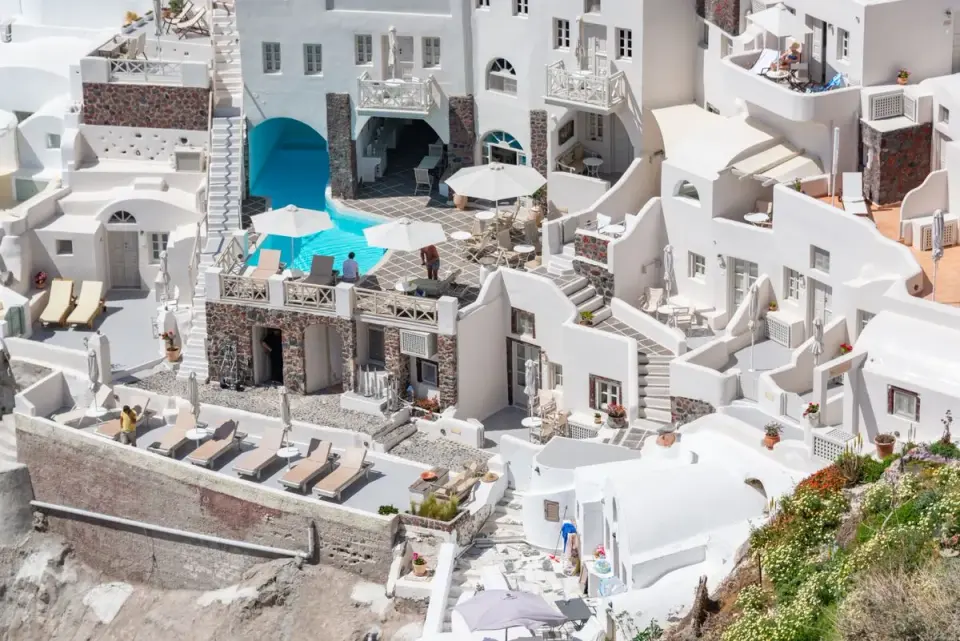 Explore the stunning white-washed buildings of Santorini with this captivating aerial view. -…