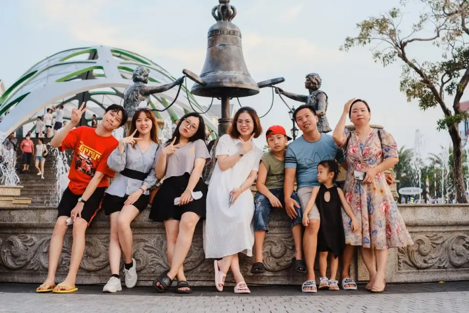 Group of happy friends and family posing near statue in Phu Quoc, Vietnam. - Photo by Thasun…