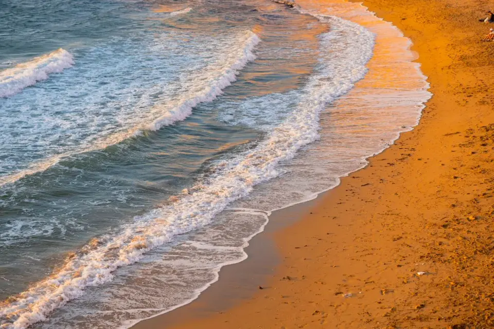 Stunning sunset waves on Gallipoli beach, Puglia, Italy creating a serene coastal landscape. -…