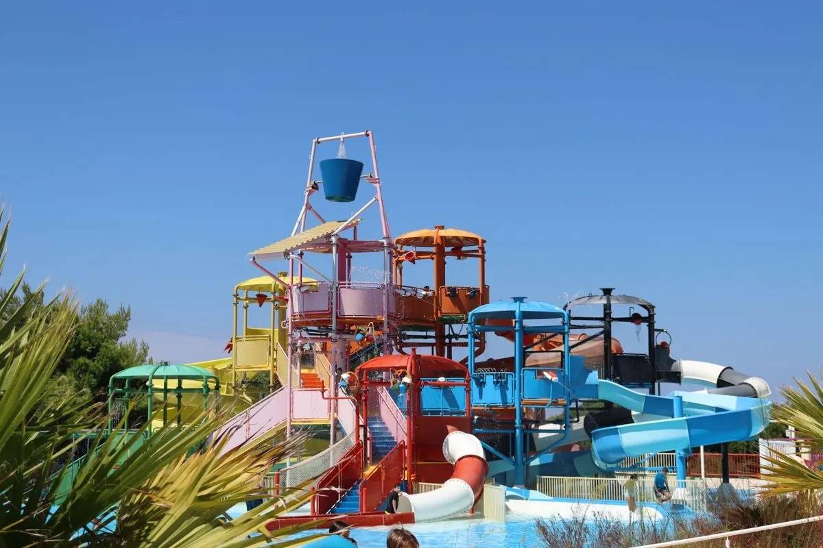 Colorful waterslides at an outdoor aquapark on a sunny summer day. - Photo by Aggeliki Siomou on…