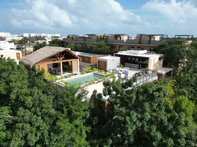 Aerial view of a luxury villa with a private pool nestled in the lush jungle of Tulum, Mexico. -…