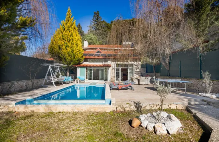 Beautiful luxury villa with a swimming pool, sunbeds, and outdoor relaxation area surrounded by…