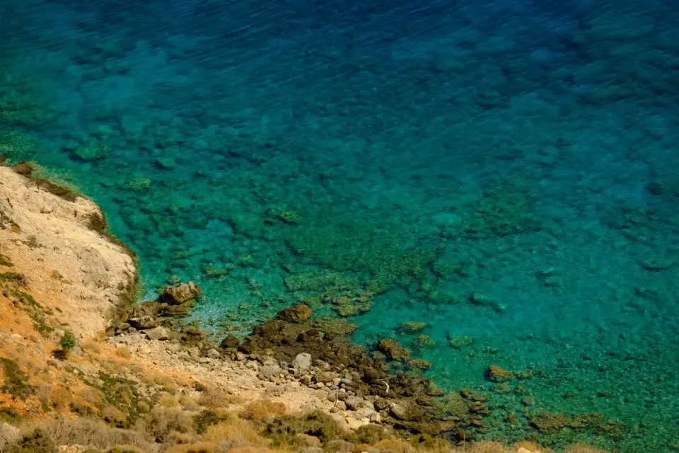 Stunning aerial view of rocky shoreline meeting clear turquoise water, perfect for nature and…