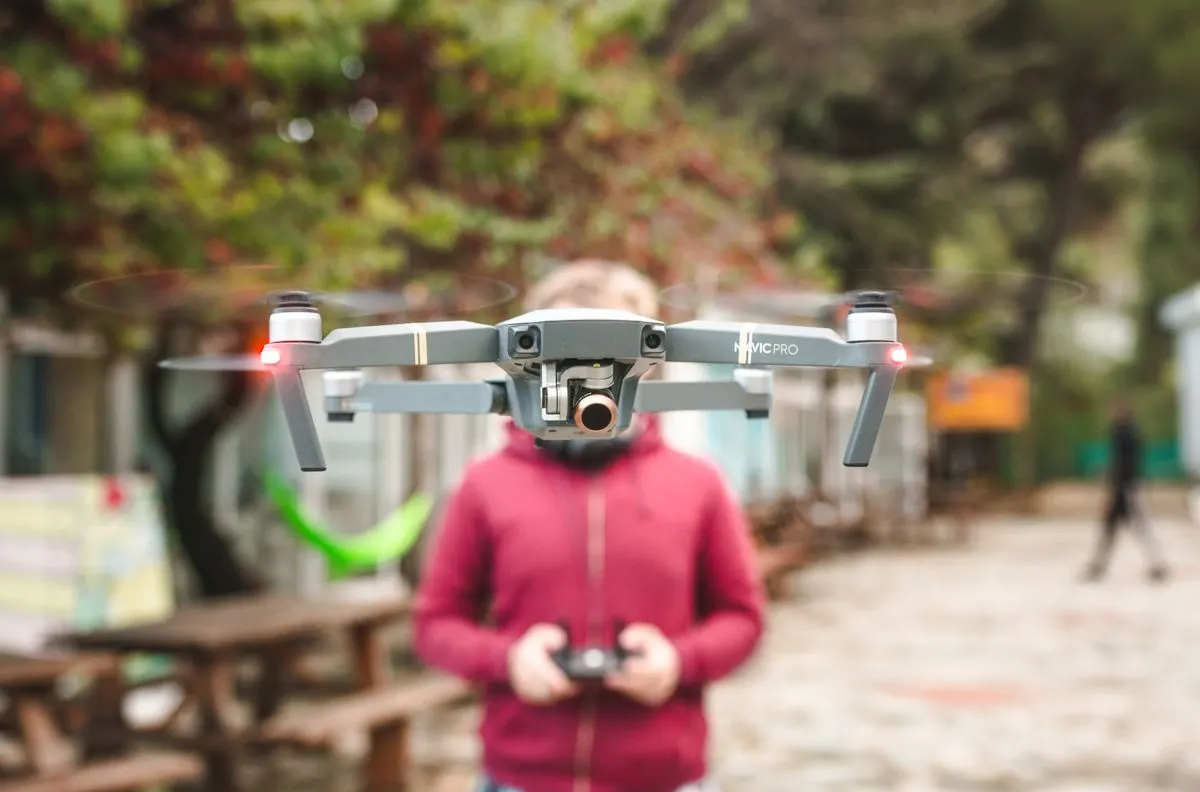 A DJI Mavic Pro drone hovers outdoors with a person controlling it in Limassol, Cyprus. - Photo…
