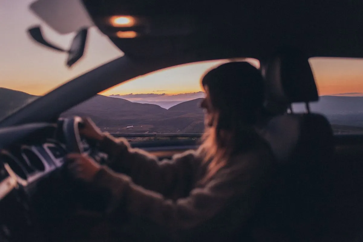 A person driving through the Scottish Highlands at sunset, capturing scenic views. - Photo by…