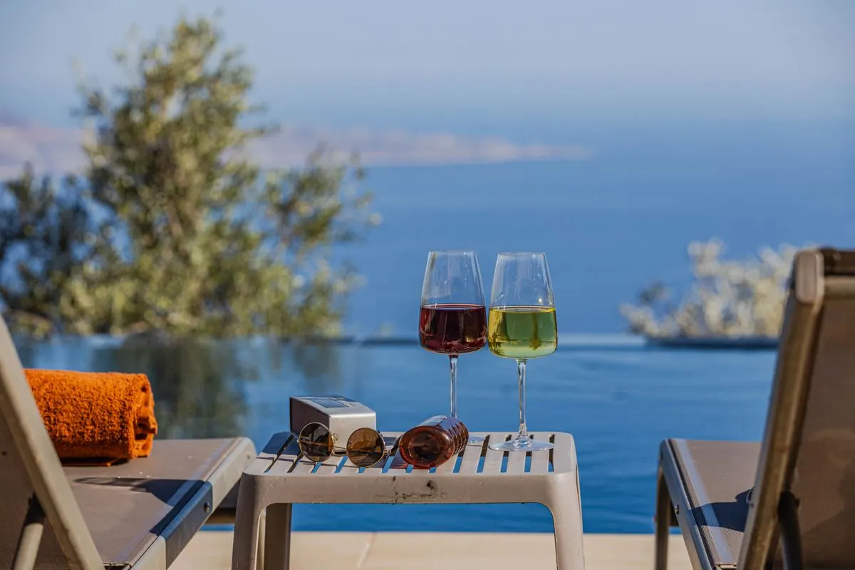 Enjoy a tranquil moment by the pool with wine and serene ocean views. Perfect for a luxurious…