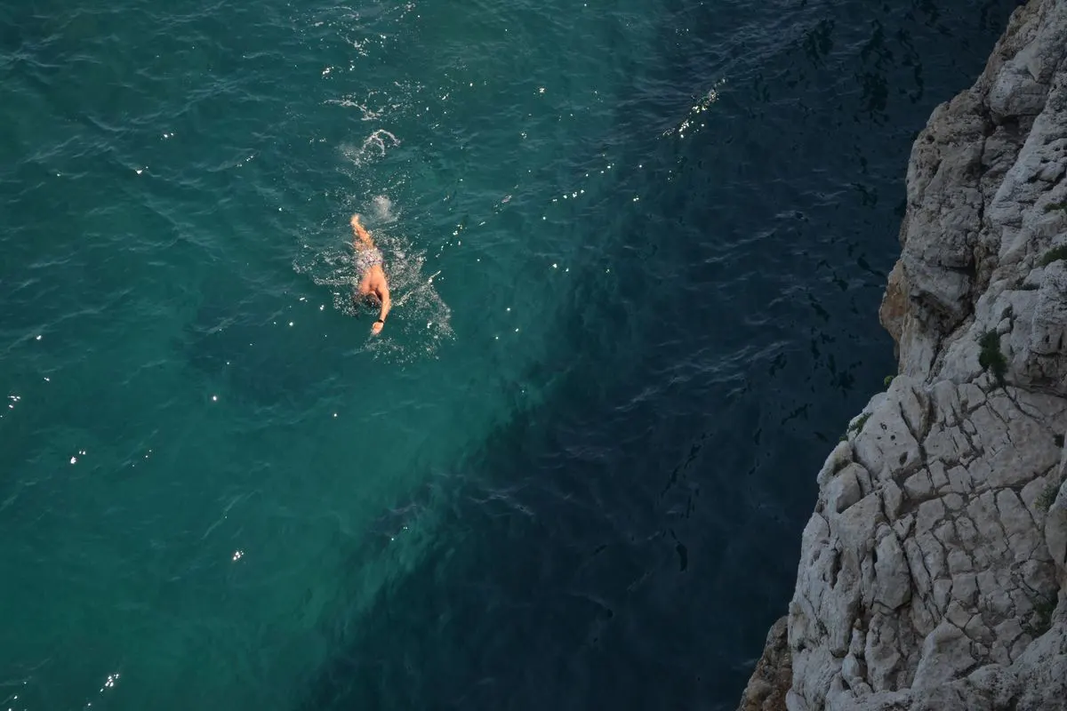 A swimmer in the blue sea by rocky cliffs at Polignano a Mare, Italy. - Photo by Ciro Palomba on…