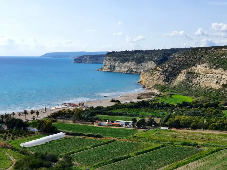 Beautiful coastal landscape featuring cliffs, green fields, and turquoise sea. - Photo by Athina…