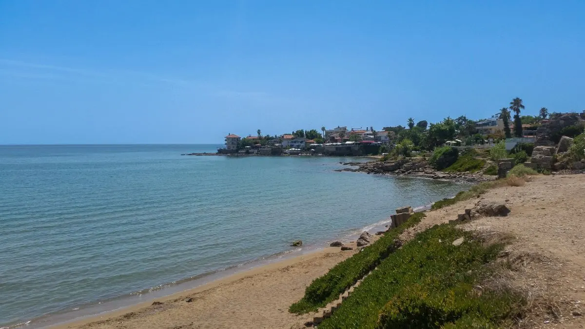 Serene beach view in Side, Antalya, Türkiye, showcasing tranquil waters and a clear sky. - Photo…