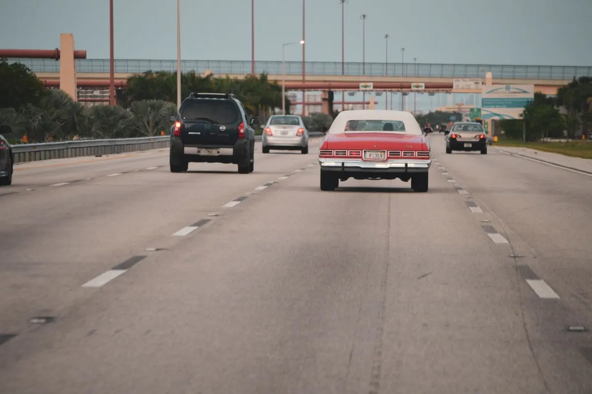Highway traffic scene with classic car in Miami, Florida, showcasing urban travel atmosphere. -…