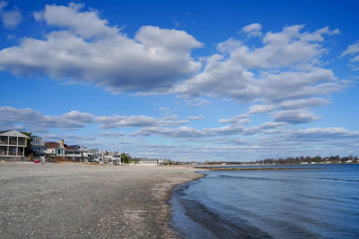 Beautiful coastal scene with beach houses and a blue sky filled with clouds. - Photo by Cara…