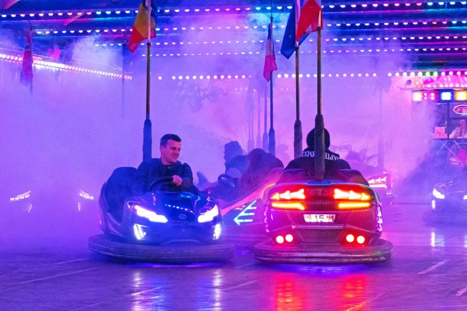 Vibrant bumper cars ride with colorful lights and smoke at a Budapest carnival. Nighttime fun…