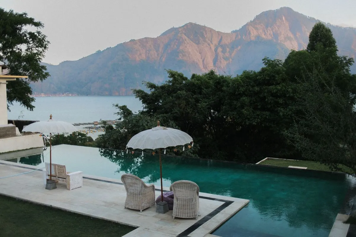 Relax by a serene infinity pool overlooking mountains and the ocean. - Photo by Evgenia Basyrova…