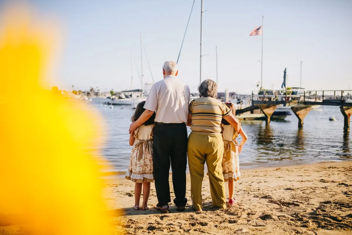 A multigenerational family enjoys a sunny day by the seaside, capturing togetherness and joy. -…