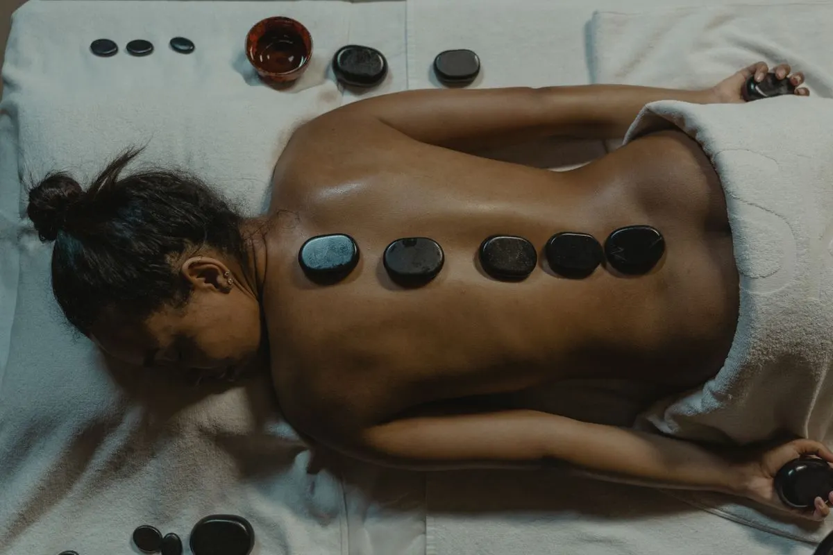 A serene spa scene with hot stone massage therapy focusing on health and relaxation. - Photo by…