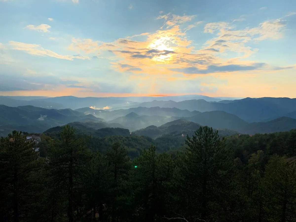 Serene sunrise over misty mountains and lush forests in Πρόδρομος, Cyprus. - Photo by Sia…