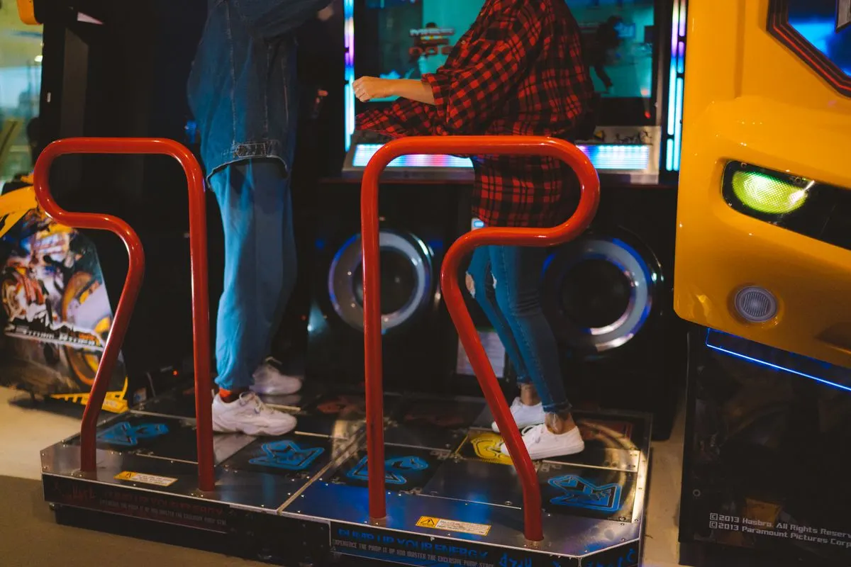 Adults having fun on a dance arcade game indoors. Vibrant, recreational, gaming fun. - Photo by…